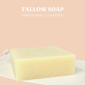 Live Tallowed handcrafted tallow soap bar with a natural, creamy color, resting on a neutral fabric surface. Set against a wooden background, featuring the Live Tallowed logo. A nourishing, all-natural soap for gentle cleansing and hydration.